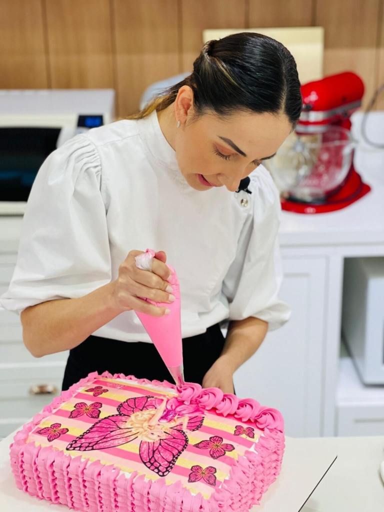 Confeiteira decorando bolo